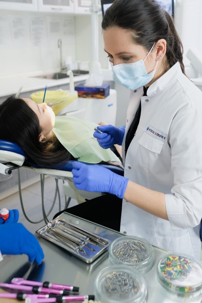 Dentist in face mask attending to a patients oral hygiene in a modern clinic setting.